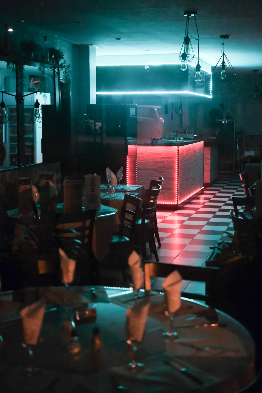 An empty restaurant, dimly lit by neon lights