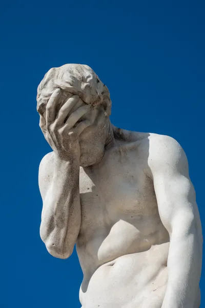 A white statue, facepalming