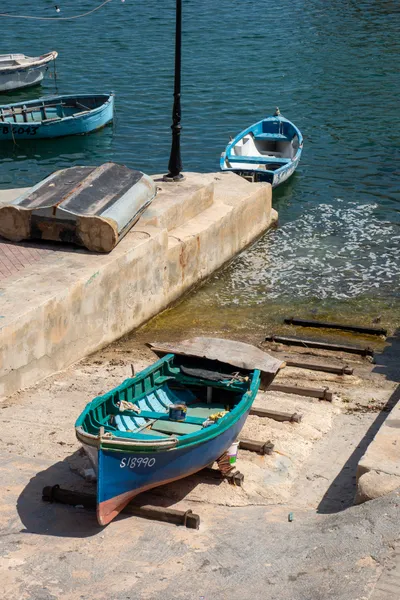 Small wooden boats parked in a port, one grounded