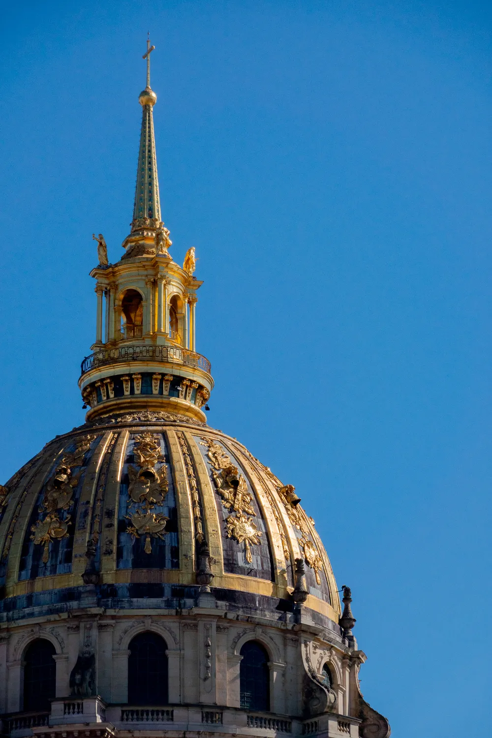 The gilded roof of the Invalides building underneath a bright blue sky