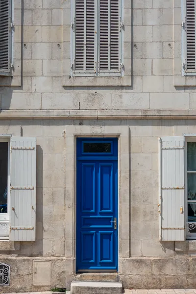 The very blue door of a plain stone building.