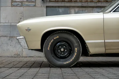 The front left of a muscle car facing the tire