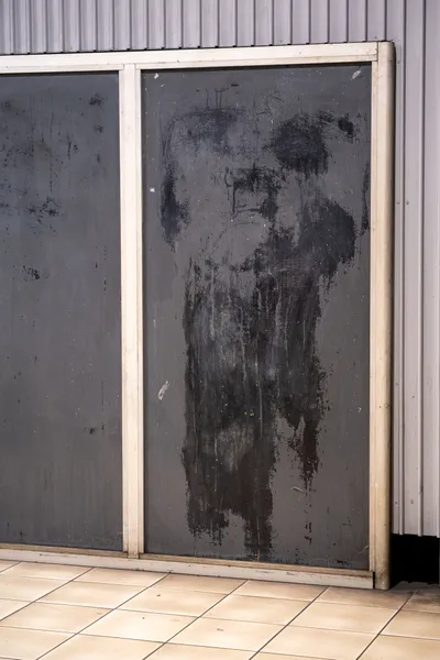 Black markings on a grey metal frame