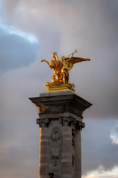 A golden statue of a winged horse and a man with a trumpet