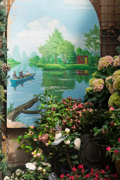A nature painting next to flowers