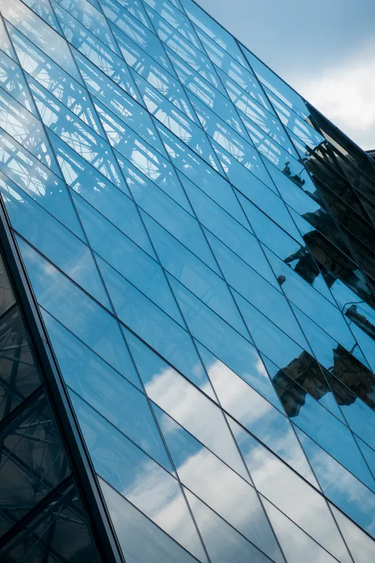 The reflection of the sky, and some clouds on a side of the Louvre glass pyramid