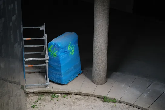 Construction equipment left in a dark concrete place, dry dirt without barely any grass