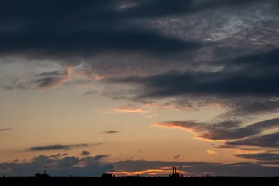 A cloudy sky after sunset, most clouds are grey but some are still lit