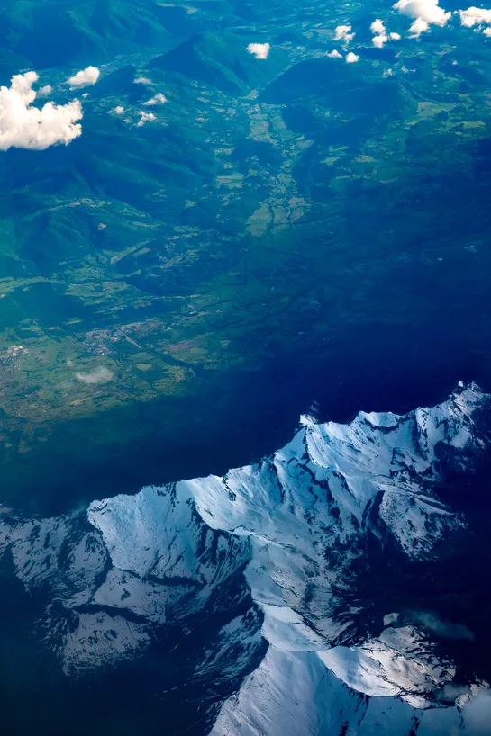 Aerial view of a mountain range overlooking a green valley