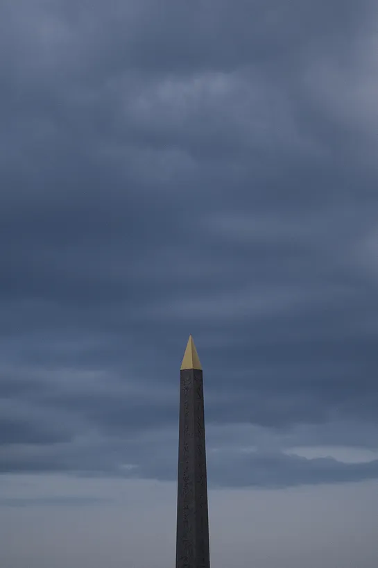 The Luxor Obelisk of the Place de la Concorde, barely lit beneath a cloudy sky