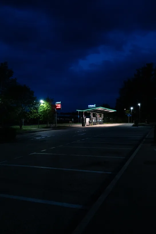 A charging station with flashy signs, in the middle of the night